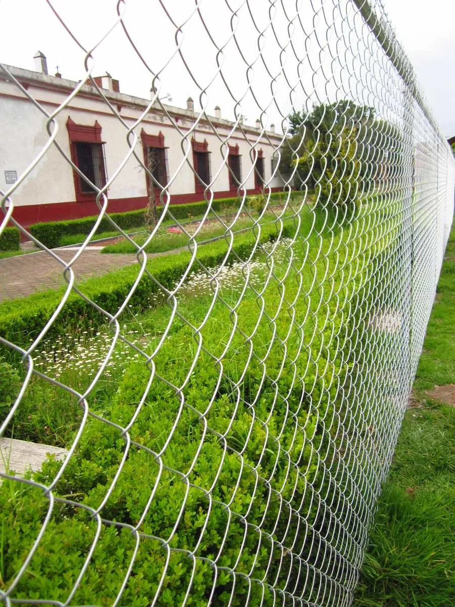 Cerca de malla ciclónica frente a una construcción